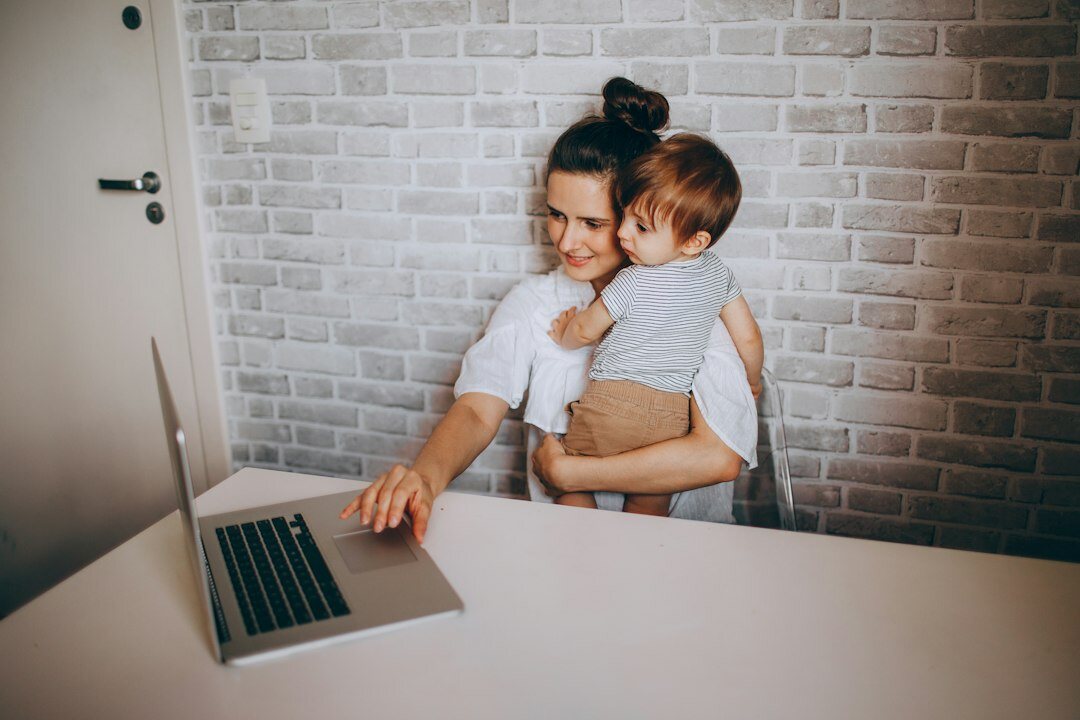 Scandinavian woman working on a laptop at a wooden desk